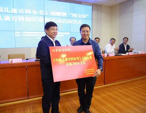 3，中国出版集团公司党组成员、副总经理陈永刚向受赠方代表赠书，青海省委宣传部副部长董杰人接受捐赠牌.jpg